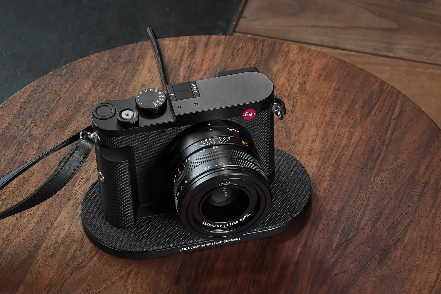 The Leica Q3 resting on a wireless charging pad, showing its fixed 28mm Summilux lens