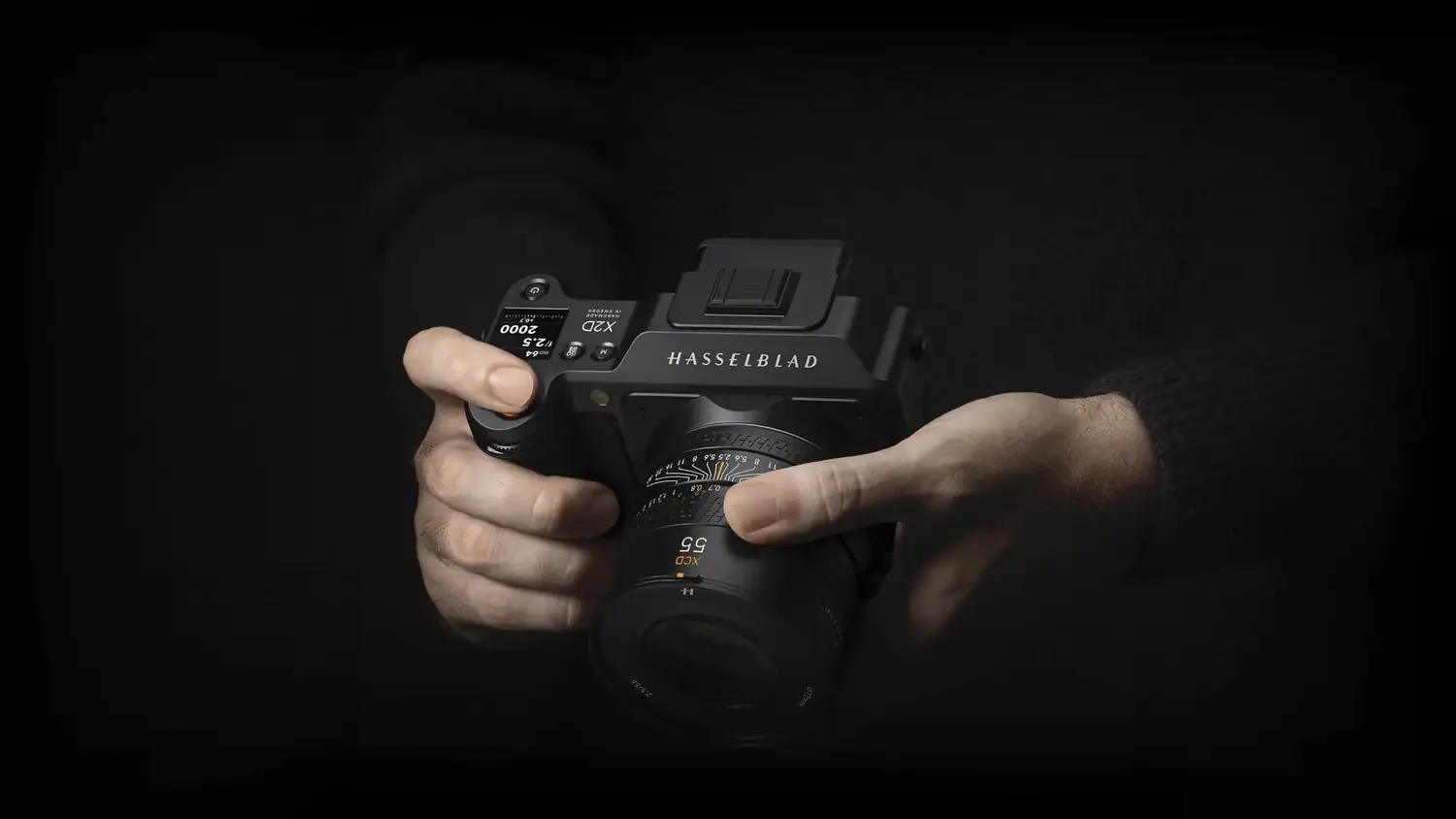 Hands holding the Hasselblad X2D 100C medium-format camera fitted with an XCD lens