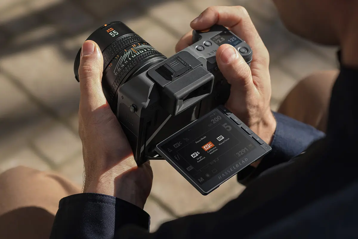 Using the Hasselblad X2D 100C on location, its tilting screen showing the focus-mode menu
