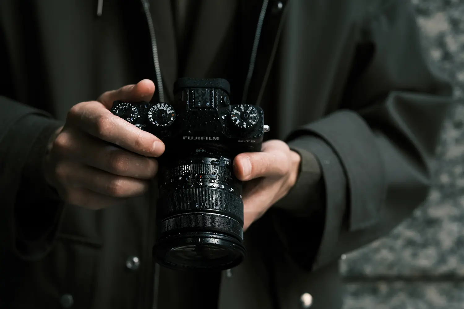 A traveller holding the weather-sealed Fujifilm X-T5 with a zoom lens