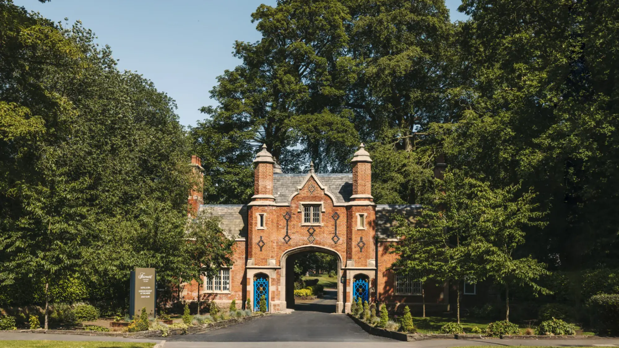 The red-brick gatehouse and tree-lined drive at The Mere, Cheshire