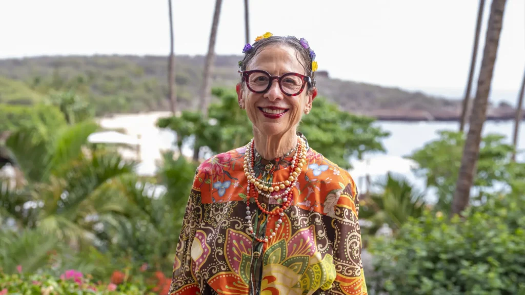 A woman in a colourful print against Lanai's greenery and sea