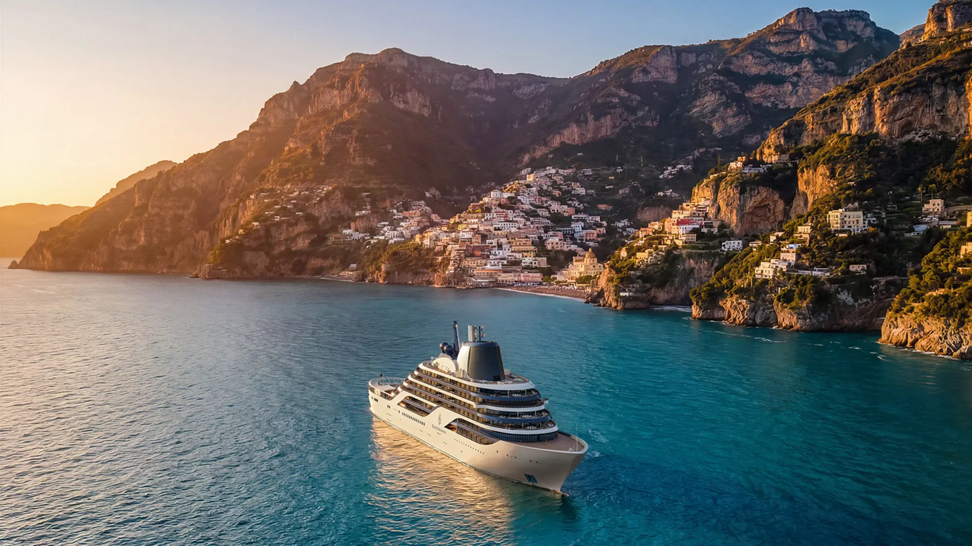 A Four Seasons yacht anchored off a cliffside Mediterranean village