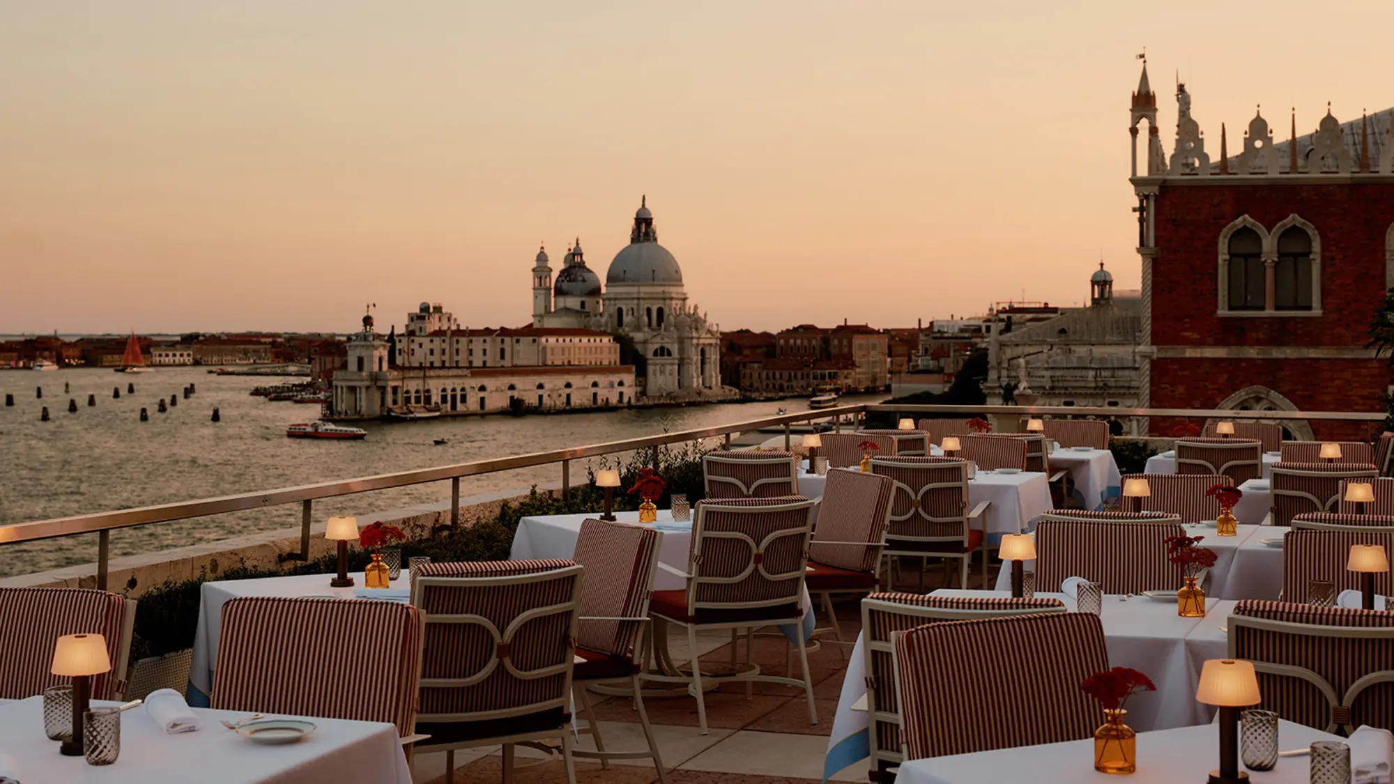 Terrazza Danieli, the rooftop restaurant at Danieli, Venezia, tables laid at sunset with Santa Maria della Salute across the basin