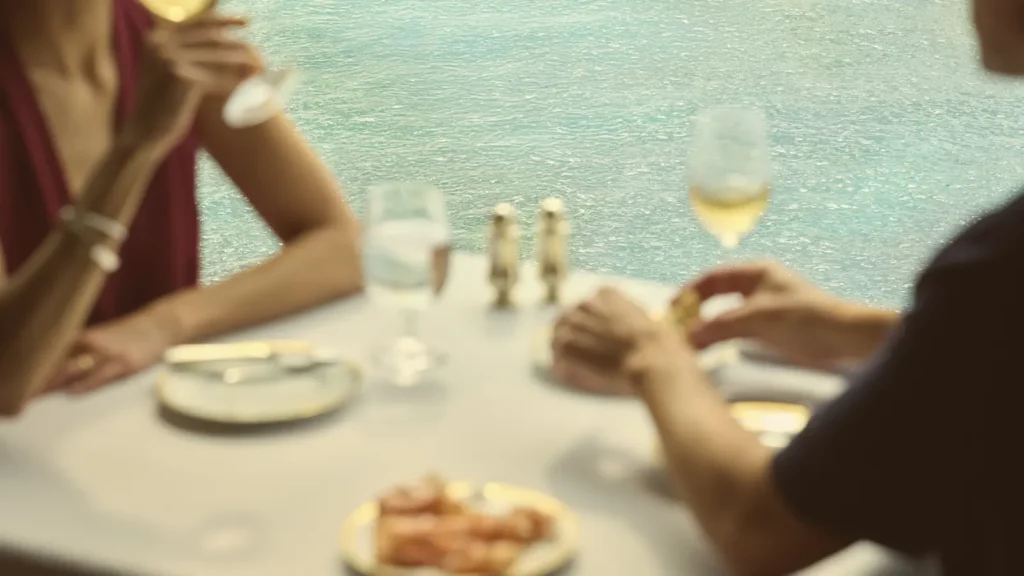 Guests at a table with a sea view aboard Oceania