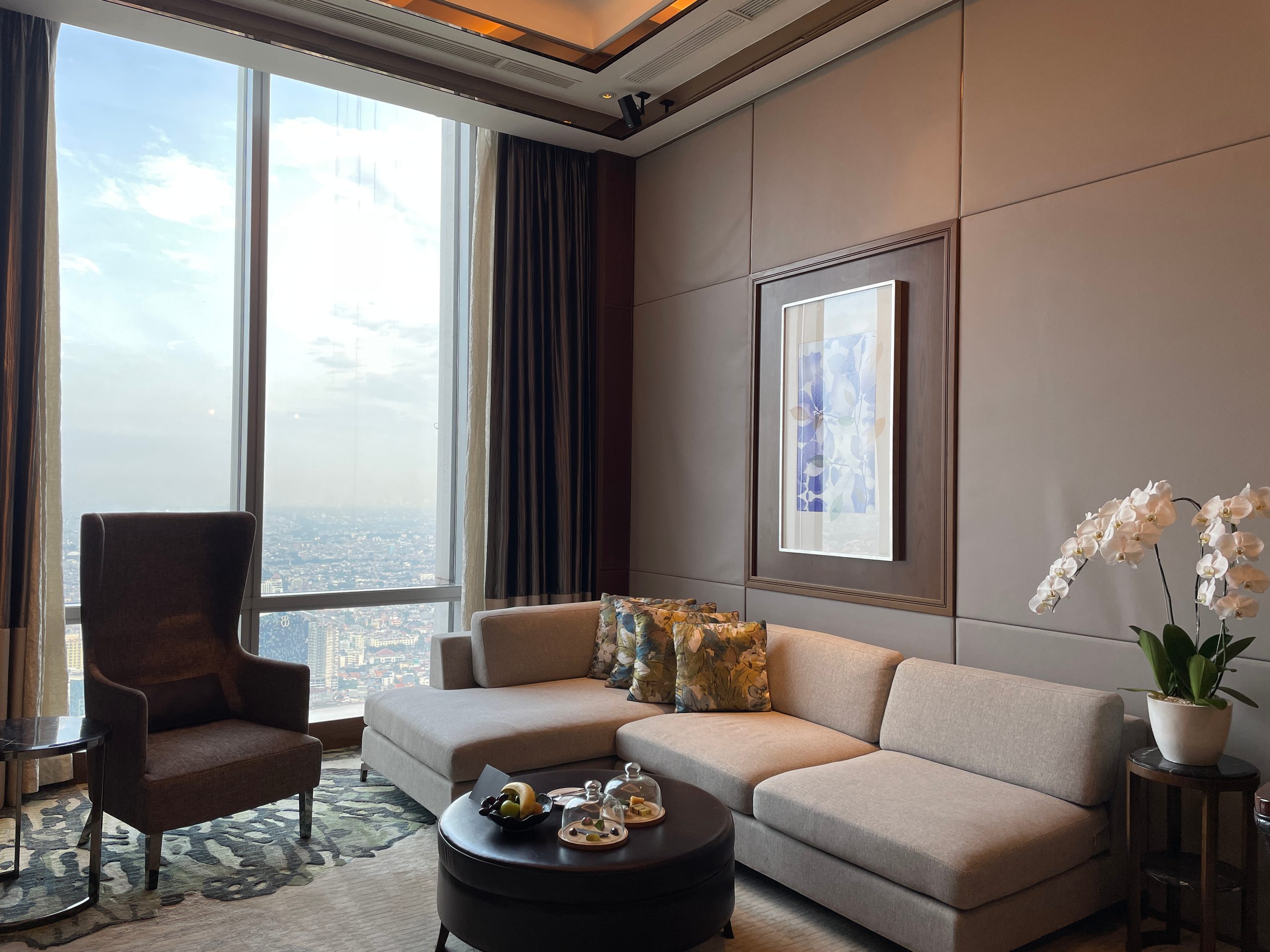 The living room, running the length of the window wall — The Westin Jakarta