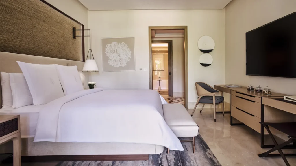 Principal bedroom of the residential suite, with a king bed, writing desk and a doorway through to the bathroom