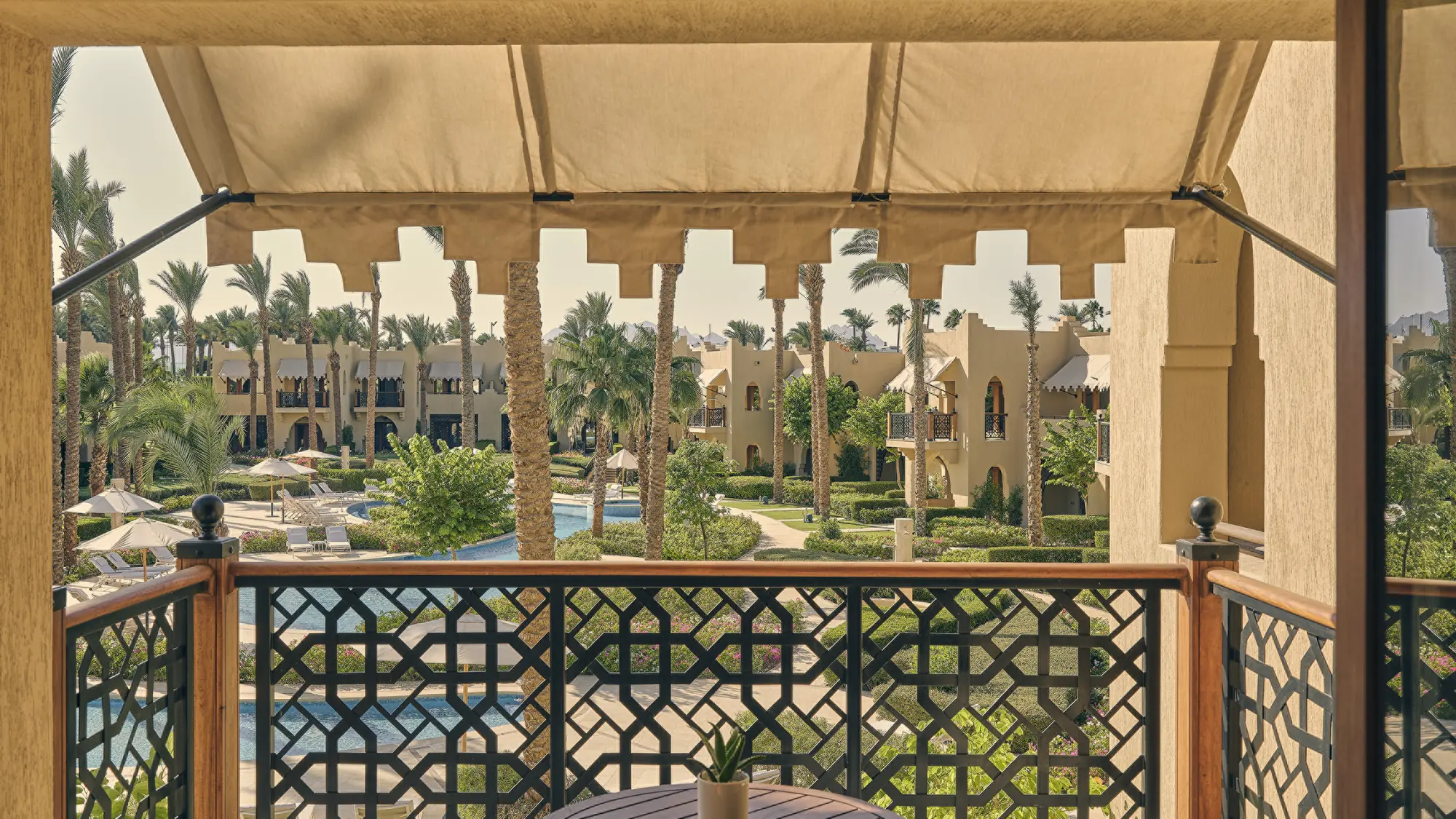Shaded terrace of the Premier Two-Bedroom Residential Suite at Four Seasons Resort Sharm El Sheikh, looking over palm-filled gardens and the pool