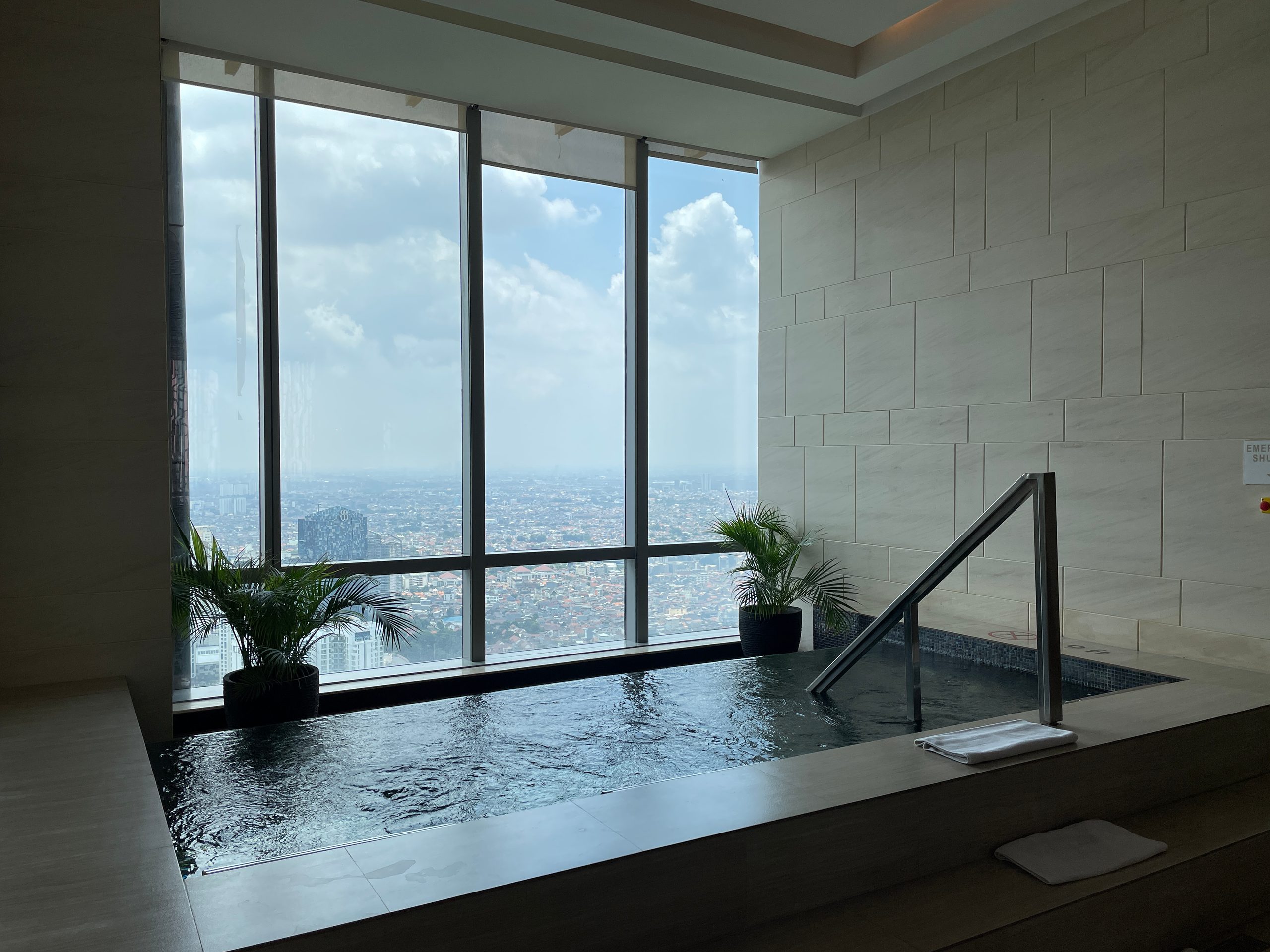The hot bath, set against the glass — The Westin Jakarta
