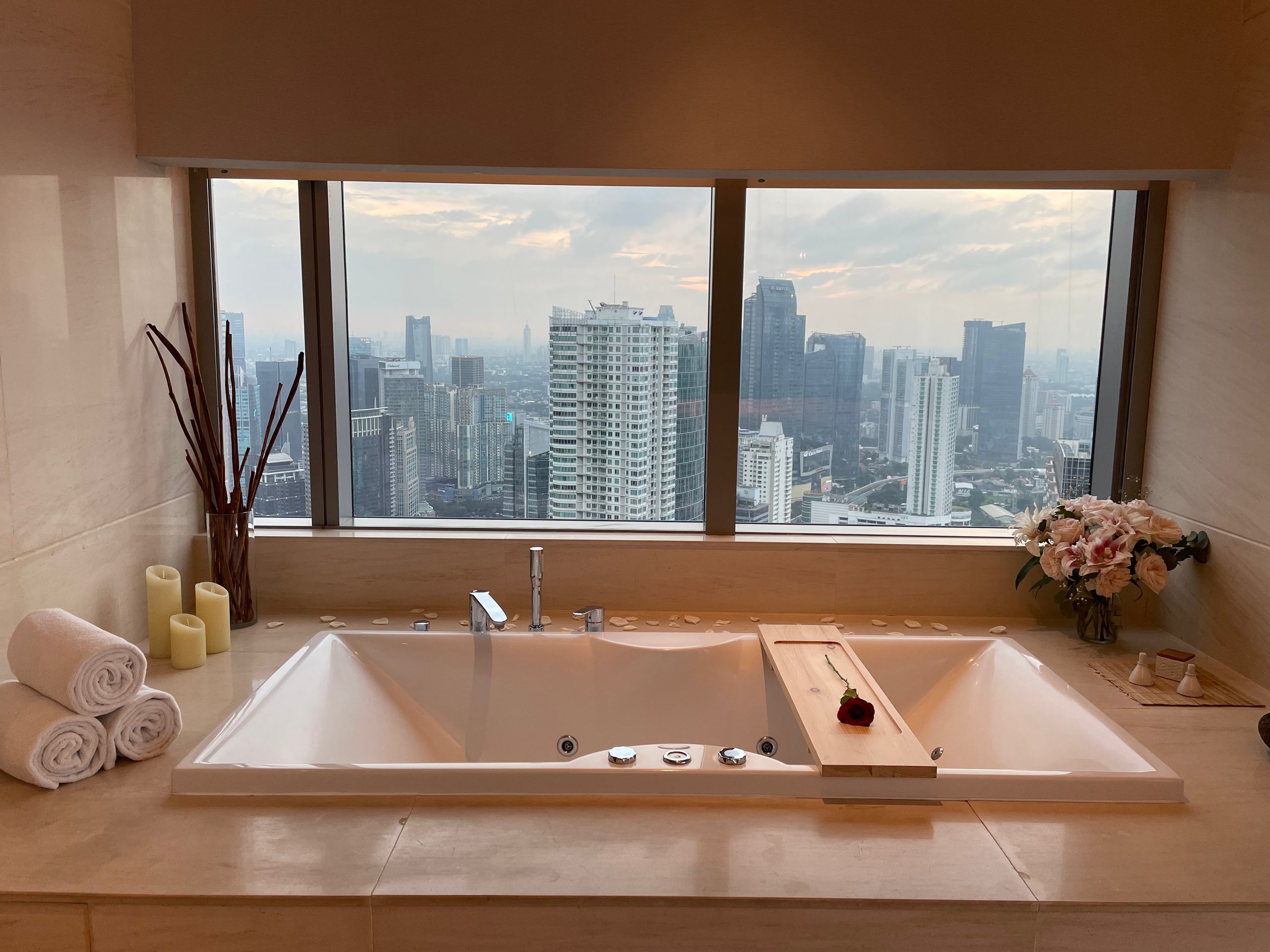 The spa bath, set beneath a window over the city — The Westin Jakarta