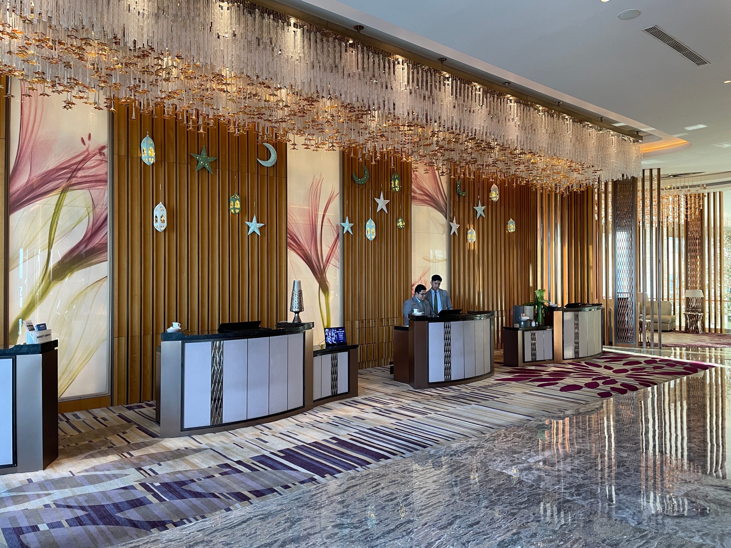 The sky lobby, with carved screens and the city beyond — The Westin Jakarta
