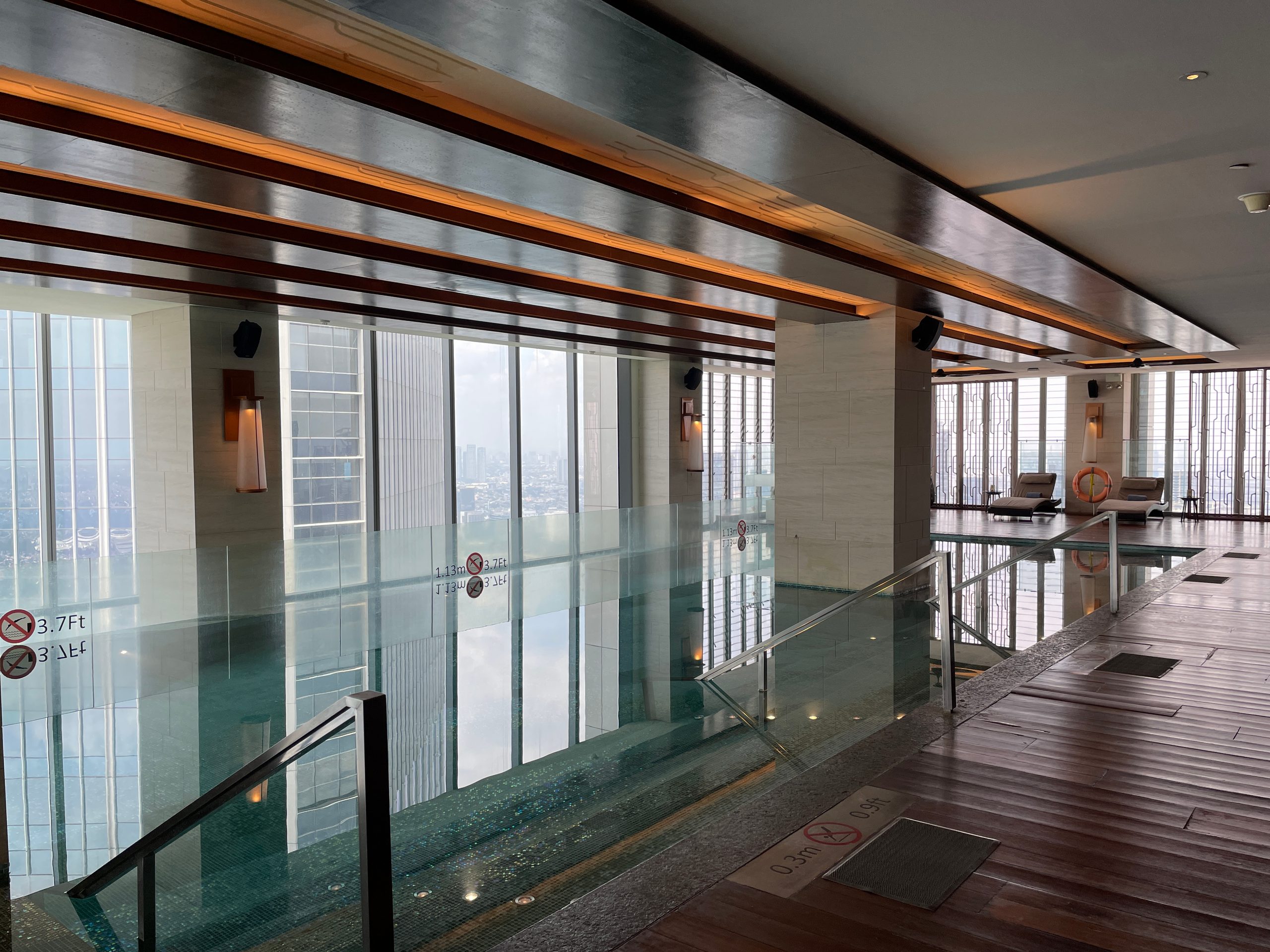 The indoor pool, glass-walled along the building's edge — The Westin Jakarta