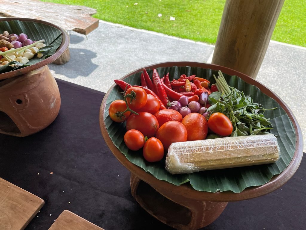 Tomatoes, red chillies, shallots and herbs on a banana leaf for the cooking class at Visesa Ubud