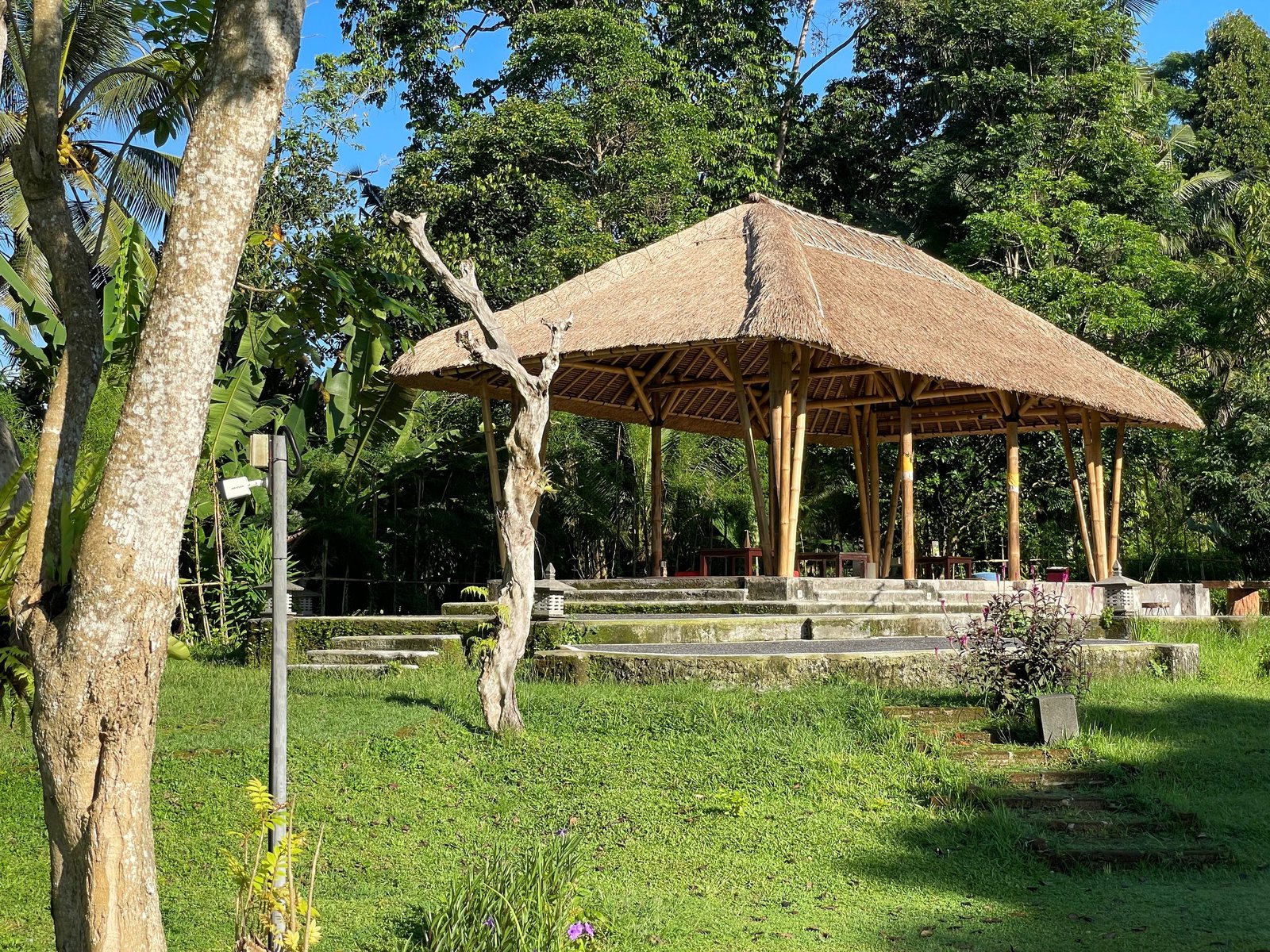The thatched open-sided pavilion used for the cooking class at Visesa Ubud, seen across the lawn