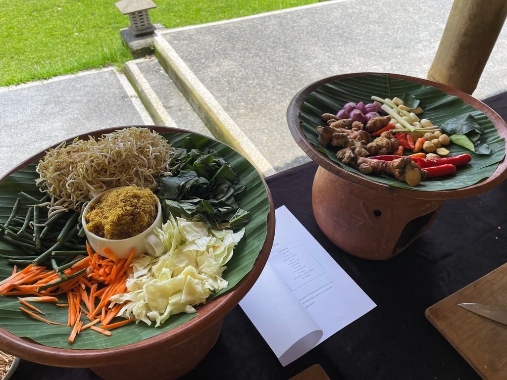 Prepared vegetables, grated coconut and aromatics on banana leaves for the cooking class at Visesa Ubud