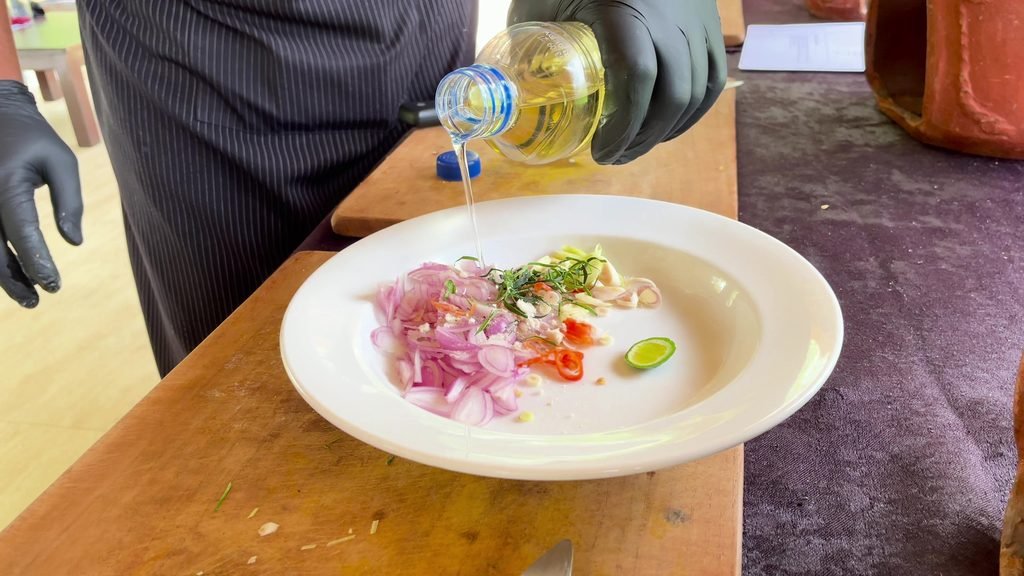 Oil being poured over sliced shallot, chilli and lime for sambal matah at the cooking class, Visesa Ubud