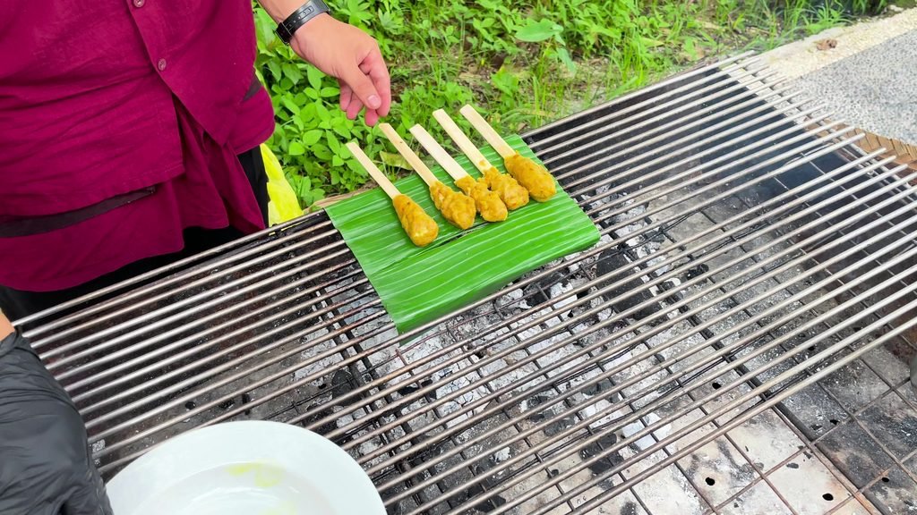 Sate lilit skewers laid on a banana leaf over the grill at the cooking class, Visesa Ubud