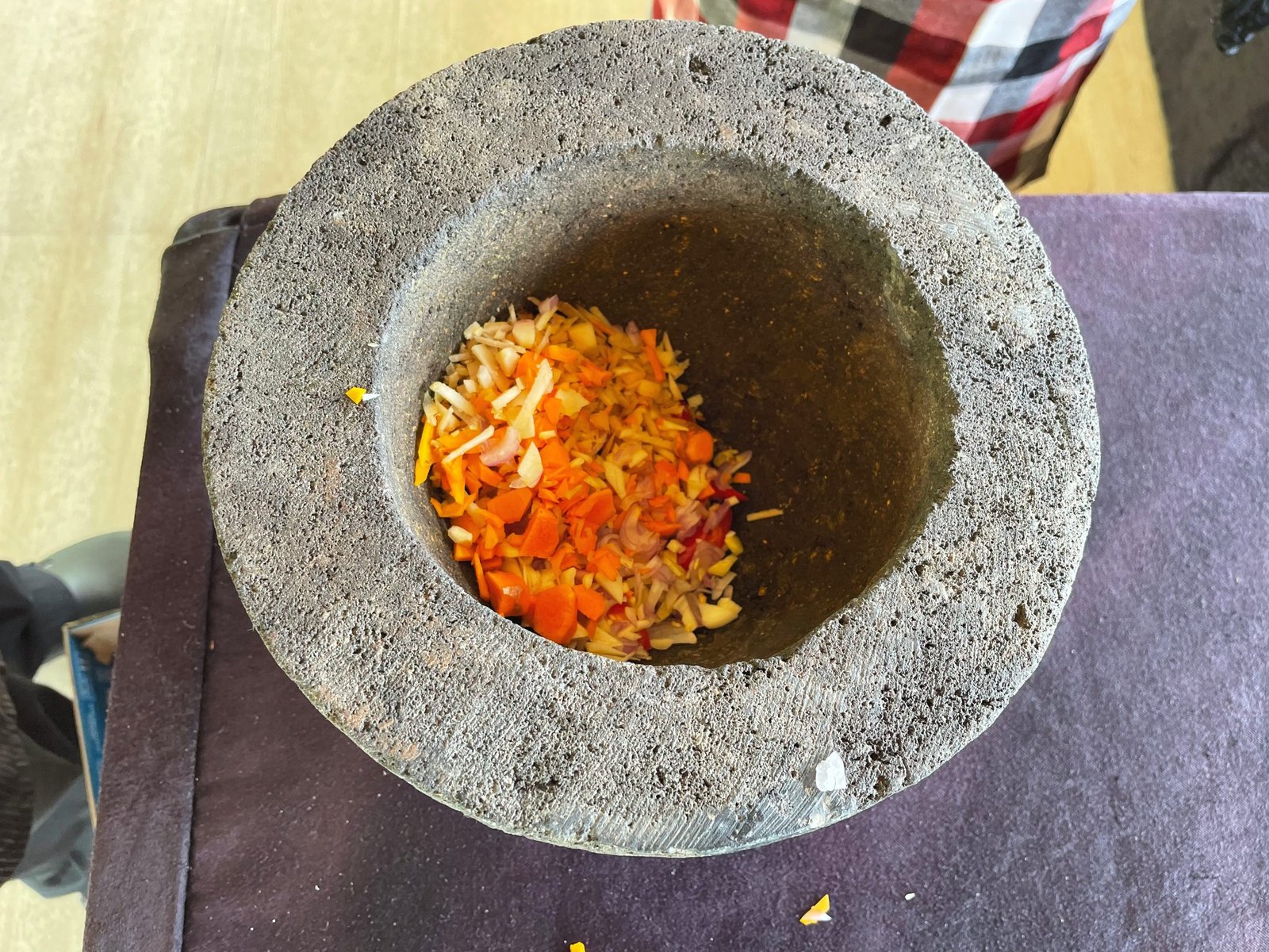 Chopped chilli, turmeric and shallot in a stone mortar at the Balinese cooking class, Visesa Ubud