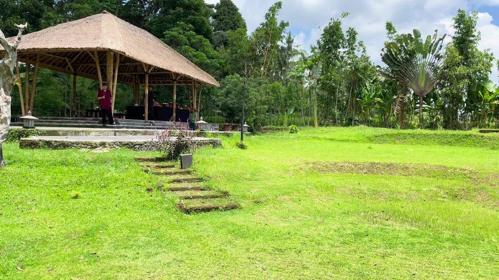 The thatched cooking pavilion at the head of the organic farm lawn at Visesa Ubud