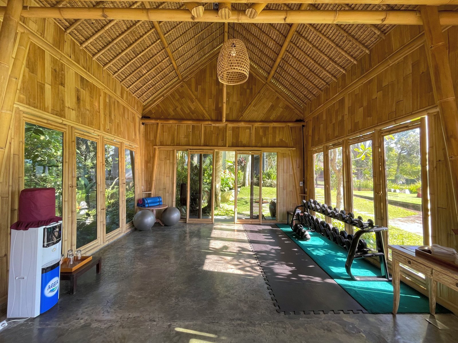 Dumbbells and exercise balls under the woven bamboo roof of the gym at Visesa Ubud