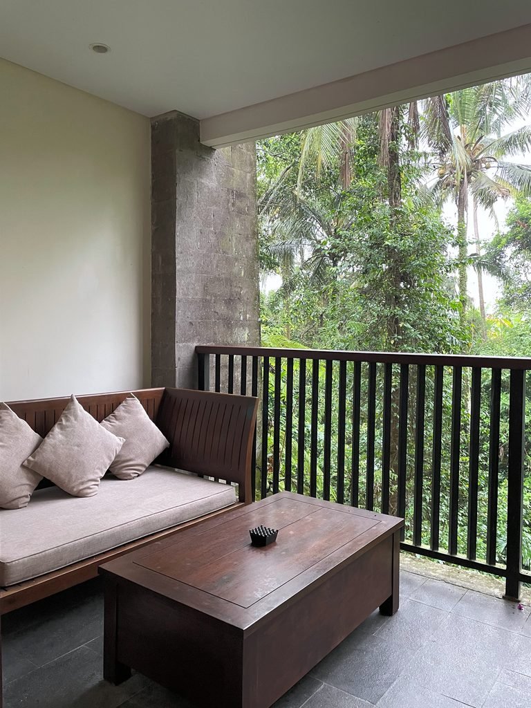 A cushioned timber daybed on the balcony of the Jungle Suite at Visesa Ubud, with jungle beyond