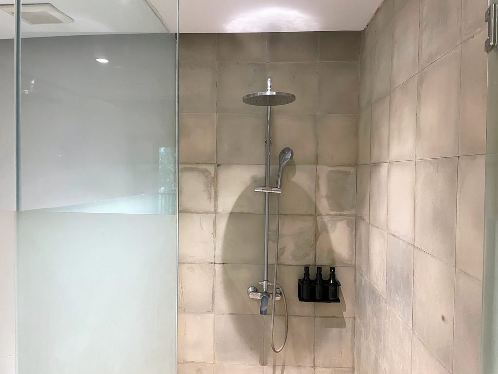 A rain shower behind frosted glass in the Jungle Suite bathroom at Visesa Ubud