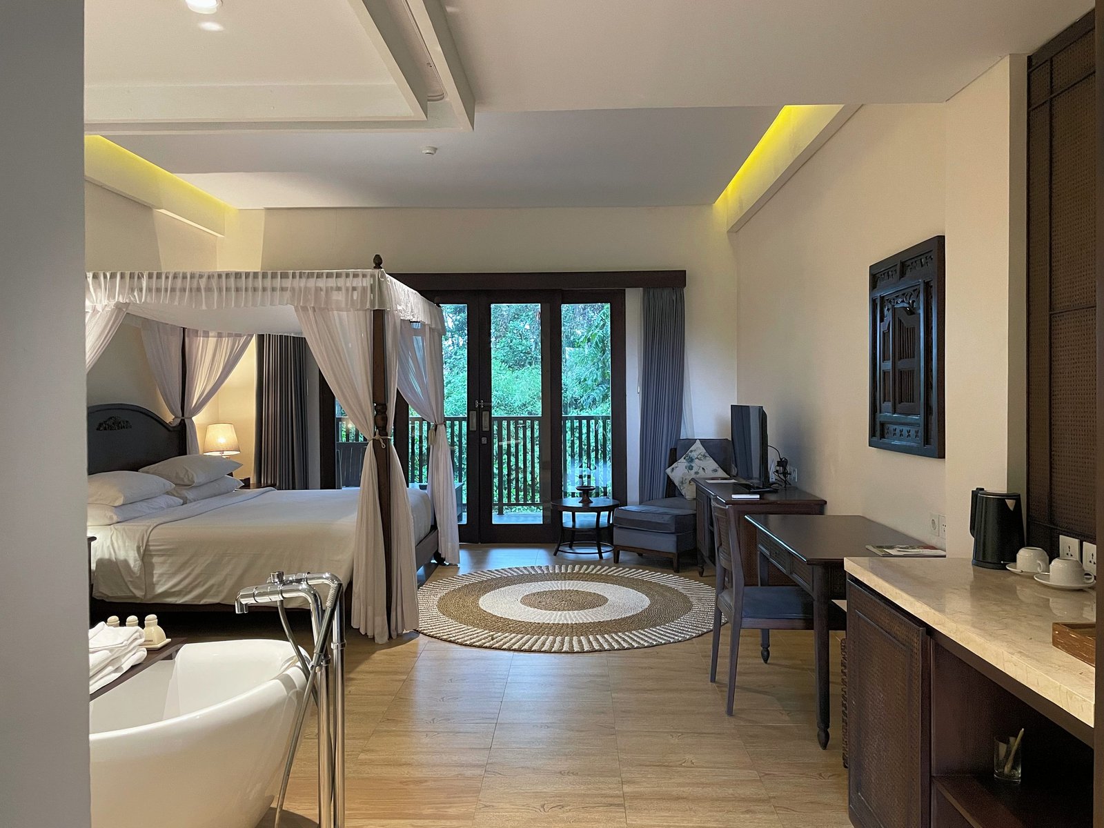 The Jungle Suite at Visesa Ubud, with a canopy bed, a freestanding bathtub and a desk under one ceiling