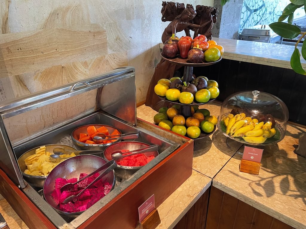 Cut papaya, pineapple, watermelon and dragon fruit beside a tiered fruit stand at the Lesung breakfast, Visesa Ubud