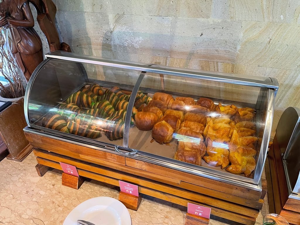 Croissants and pastries in a glass case at the Lesung breakfast buffet, Visesa Ubud