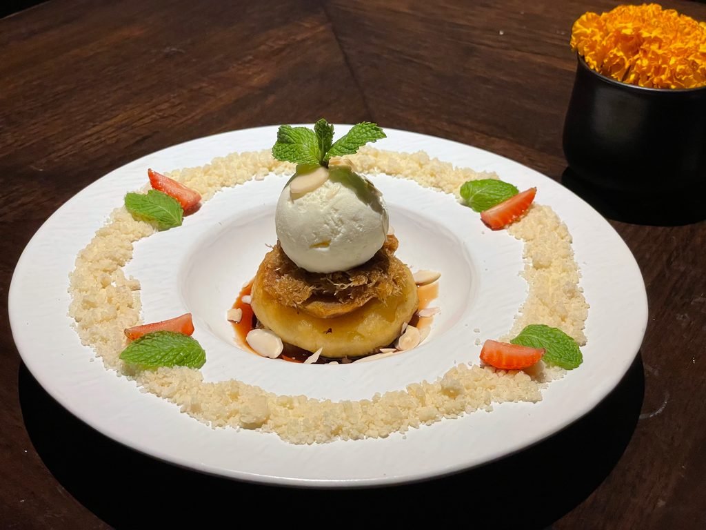 A plated dessert topped with ice cream and mint at Lumbung restaurant, Visesa Ubud