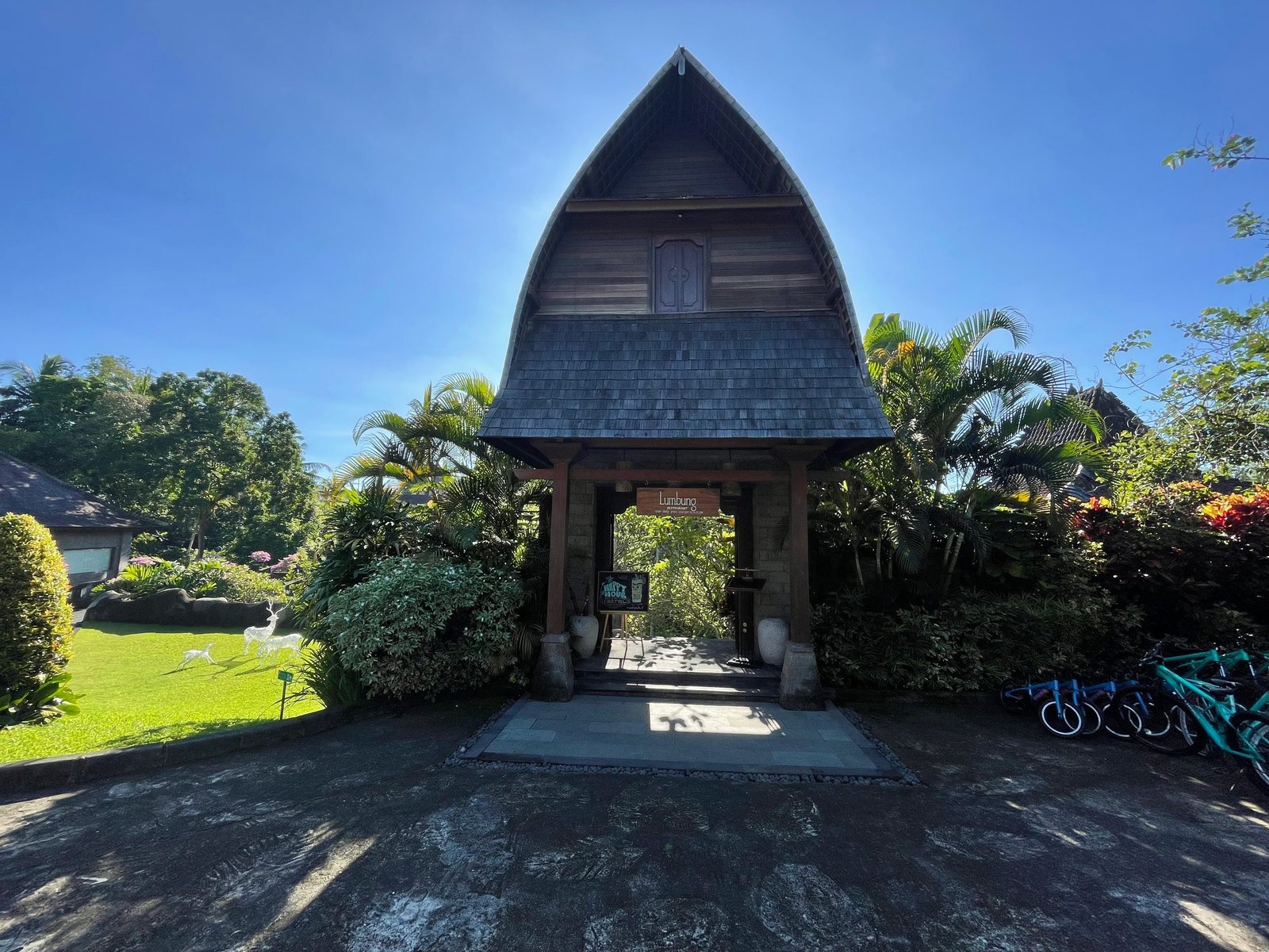 The tall shingle-roofed gate to Lumbung restaurant at Visesa Ubud, shaped like a traditional Balinese rice barn