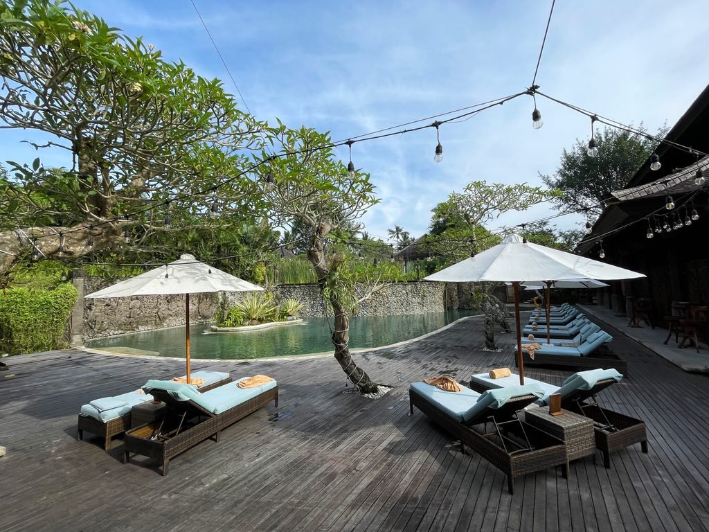 Loungers under festoon lights strung across the pool deck at Visesa Ubud