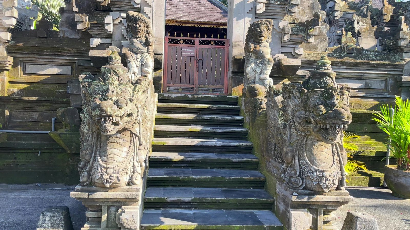 Carved stone guardian statues flanking the steps to the temple at Visesa Ubud