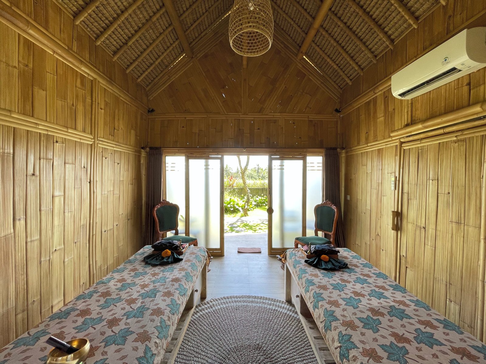 A couples' treatment room at Visesa Spa, Visesa Ubud, facing its doors to the garden