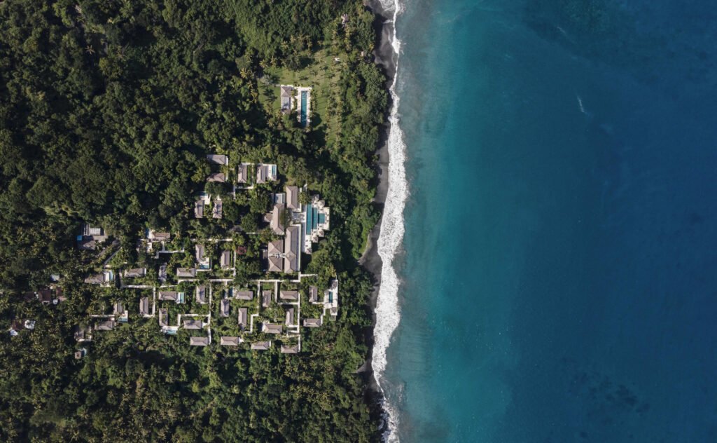 Amankila from the air, its villas in the forest above the black-sand coast of East Bali