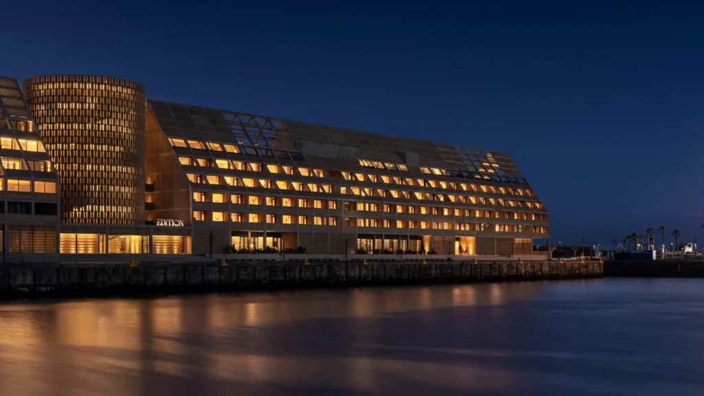 The Cape Town EDITION lit up at dusk, reflected in the V&A Waterfront harbour