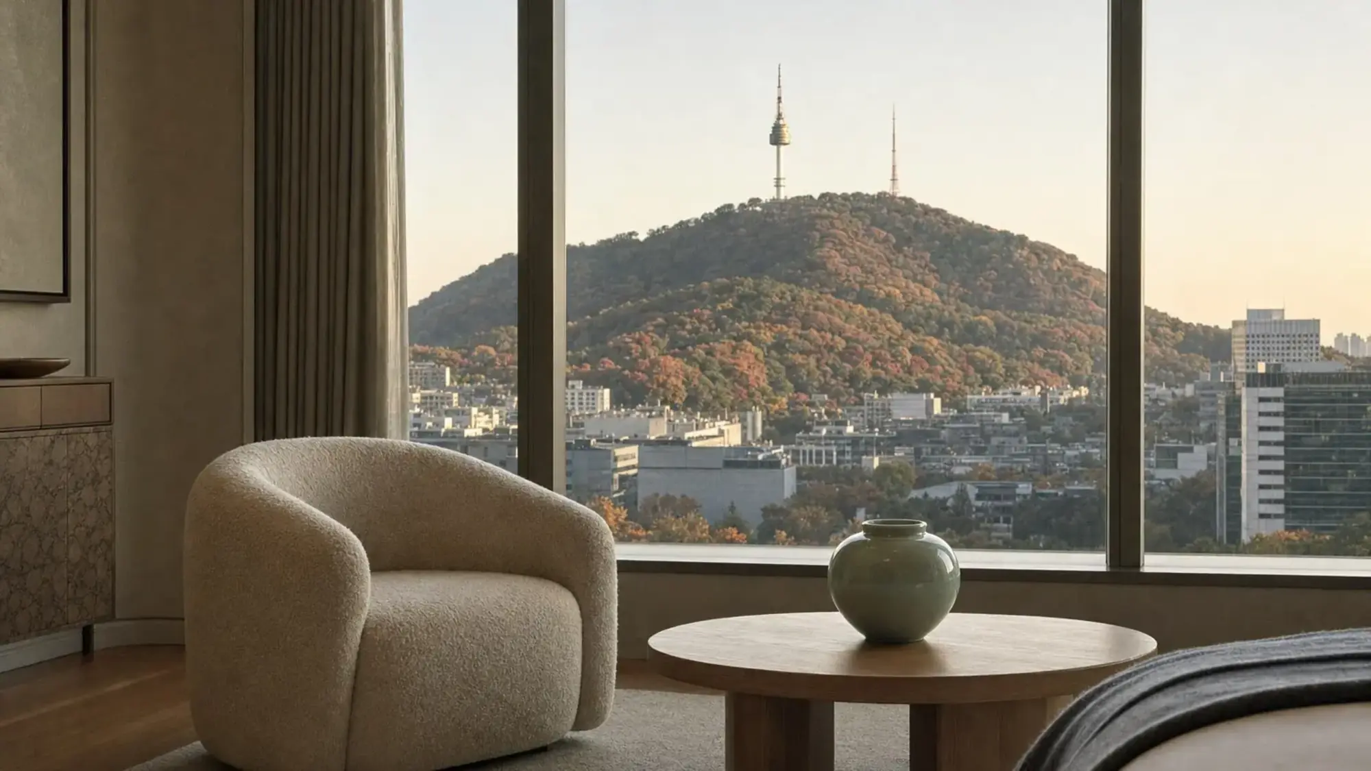 Illustration of a hotel room armchair facing a window view of Namsan and N Seoul Tower in autumn