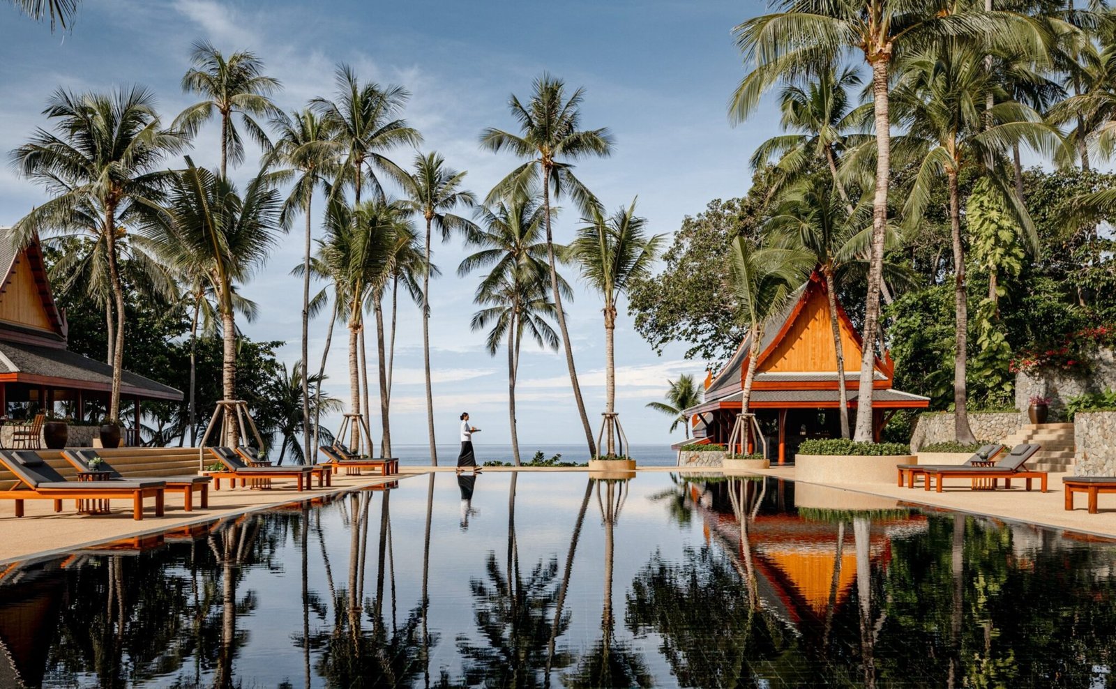 Amanpuri's black-tiled pool reflecting palms and Thai pavilions above the Andaman Sea