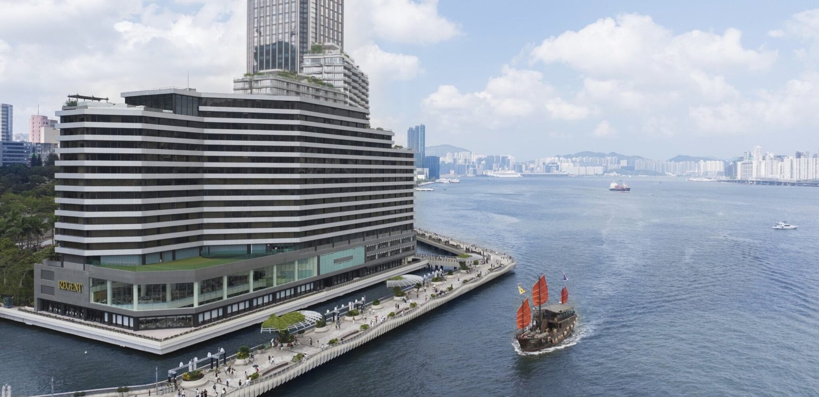 Regent Hong Kong on the Tsim Sha Tsui waterfront, with a red-sailed junk in Victoria Harbour