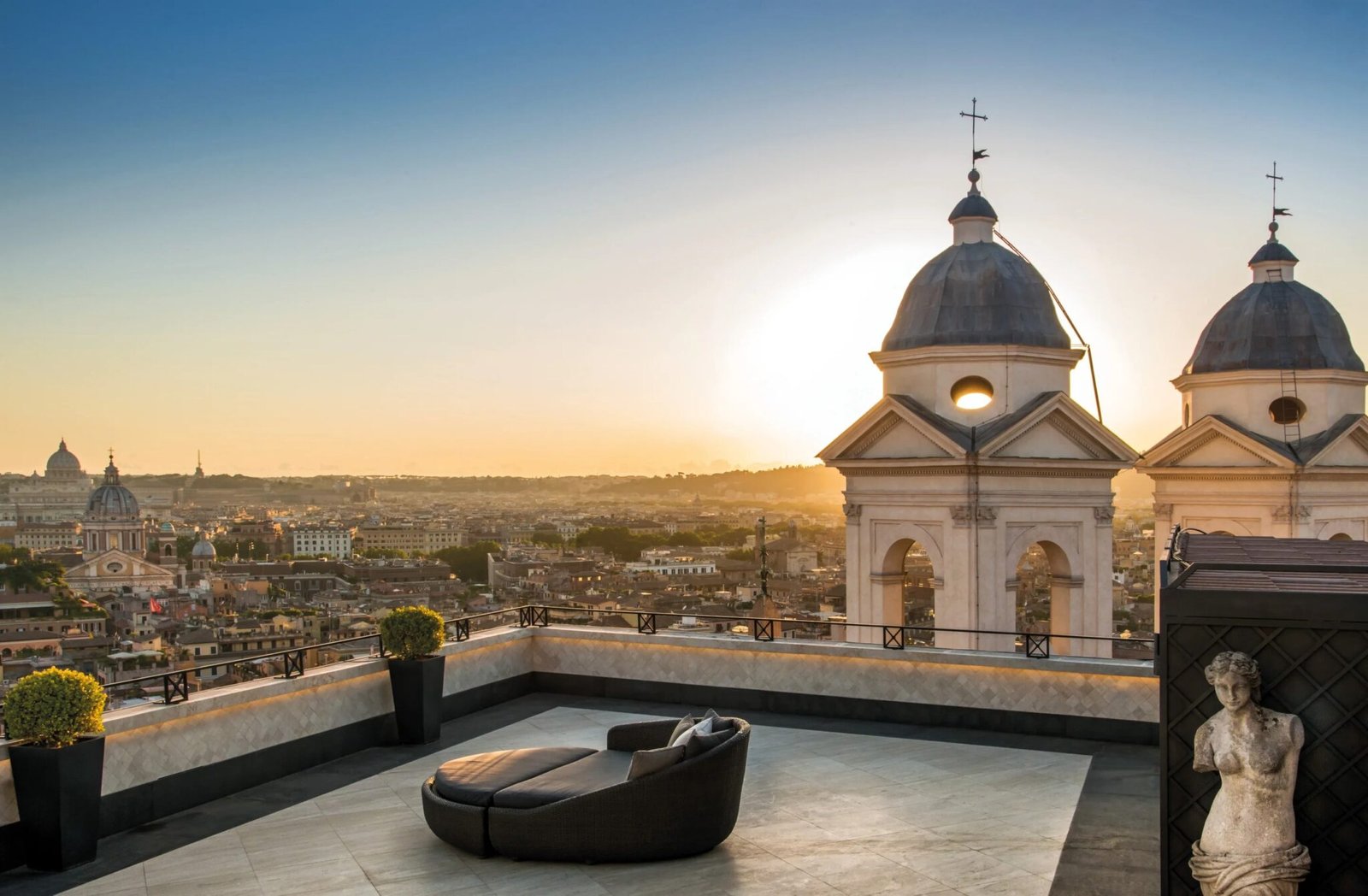 Roof terrace at Hassler Roma beside the bell towers of Trinità dei Monti at sunset