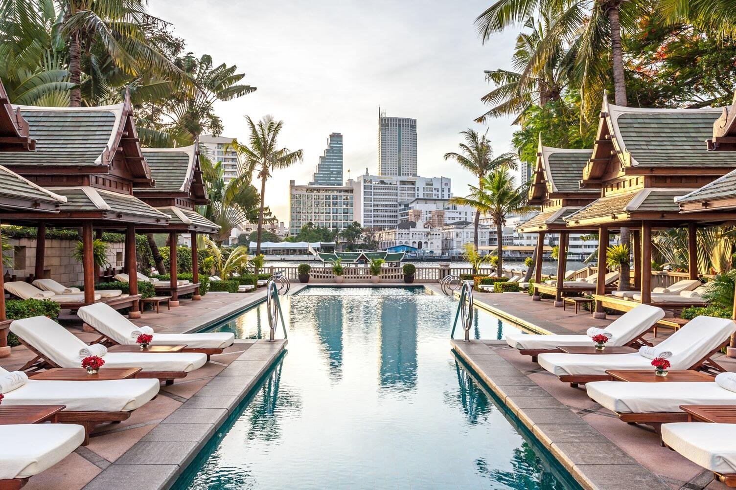 The Peninsula Bangkok's riverside pool and Thai salas, with the Chao Phraya and the city skyline beyond
