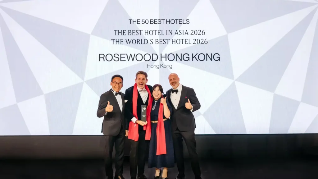 Four people in evening dress holding a trophy on stage beneath a screen reading The World's Best Hotel 2026, Rosewood Hong Kong