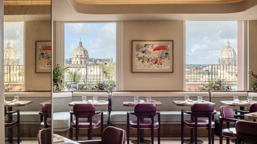 Restaurant with plum-coloured chairs and banquettes, windows looking onto church domes