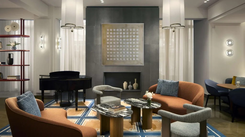Hotel lounge with a grand piano, fireplace and leather armchairs at Tivoli President Milano